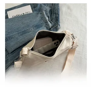 Interior view of off-white canvas crossbody bag showing large storage capacity