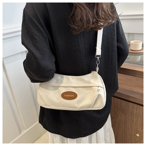 Dettaglio borsa hobo in tela bianco sporco con patch FASHION e tracolla larga