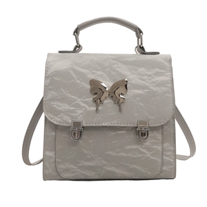 Silver-gray wrinkled leather handbag featuring a large metal butterfly and twin square locks