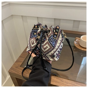 Close-up of ethnic bucket bag featuring geometric embroidery and leather drawstring