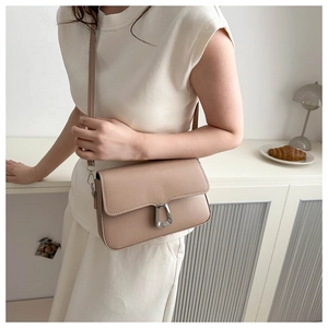 Detail of the chic silver metal U-lock closure on a minimalist beige leather handbag