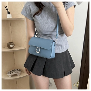 Close-up of stylish misty blue crossbody bag worn by a model in a casual setting
