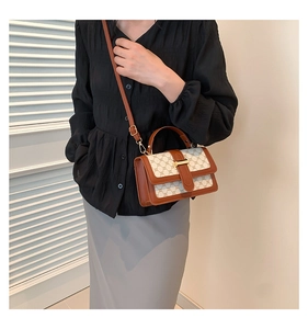 Side view of model wearing a vintage cream canvas crossbody bag with brown leather trim