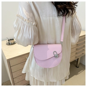 Pink semi-circle saddle bag with silver metal buckle on a white pleated dress model