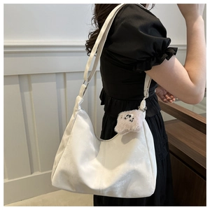 Gros plan sur le sac fourre-tout léger en suédine blanche avec un porte-clé panda