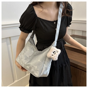 Sac hobo métallisé argenté avec breloque étoile en peluche porté à l'épaule pour femme