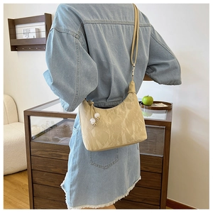 Beige pleated crescent shoulder bag with pearl zipper detail on a fashion model