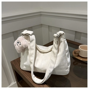 Détail du sac fourre-tout blanc cassé avec texture en daim et pendentif chien en peluche