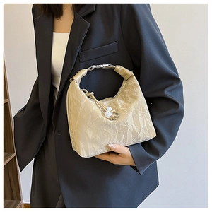 Detail of crinkled cream handbag with silver metal ring handle and bead drawstring