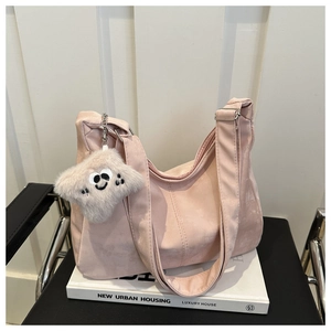 Détail du sac cabas rose en suédine avec boucle argentée et charm peluche souriant