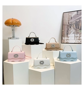 Macro shot of stylish square bags with rhinestone buckles in various pastel colors