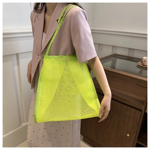 Neon green mesh tote bag with large eyelet texture shown on model for summer outfit