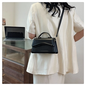 Chic black leather handbag with wavy textured flap and gold hardware for women