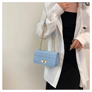 Détail du sac bandoulière matelassé bleu clair avec chaîne dorée et fermoir vintage