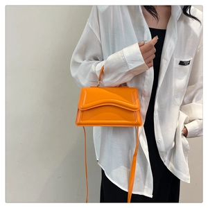 Détail d'un sac à bandoulière orange avec surpiqûres décoratives à motif ondulé