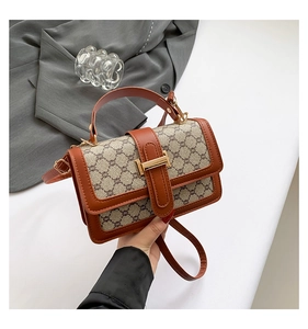 Detail of vintage crossbody bag with brown leather trim and classic monogram pattern
