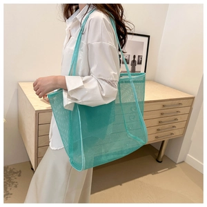 Detail of mint green mesh tote bag showing breathable fabric and long shoulder straps