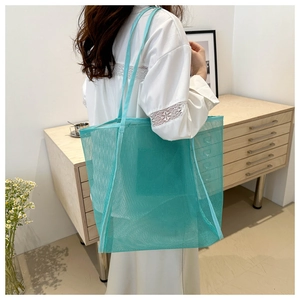 Detalle del bolso tote de malla verde azulado con gran capacidad y tejido transpirable