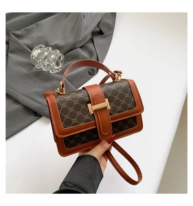 Detailed view of vintage monogram crossbody bag with gold buckle and brown leather trim