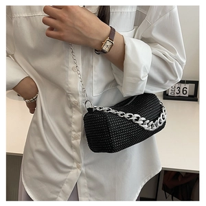 Close-up of black rhinestone cylinder bag with shiny crystals and silver chain strap