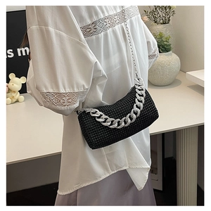 Sac de soirée élégant en strass noirs avec chaîne argentée, porté par un mannequin