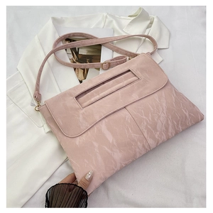 Détail du sac cabas rose montrant la texture plissée unique et la fine bandoulière