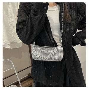 Détail du sac cylindrique argenté avec strass et grosse chaîne à l'éclat cristallin