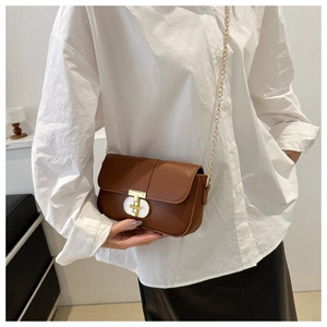 Detail of vintage brown leather square bag with gold oval twist lock and chain strap