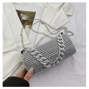 Détails macro d'un sac de soirée cylindre argenté avec strass brillants et chaîne fine