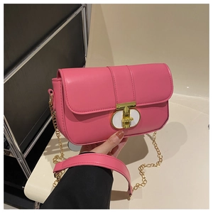 Detail of pink faux leather crossbody bag with golden chain and stylish metal lock