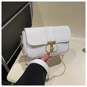 Close-up of a white leather crossbody bag with a gold T-bar metal clasp and chain