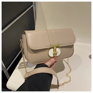 Detail of beige PU leather bag featuring a gold mechanical twist lock and metal chain strap