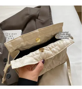 Detail view of the hidden magnetic clasp and quilted pattern on a beige bucket bag