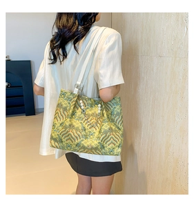 Detail of elegant wave pattern embroidery on the shoulder bag with pearl bead chain