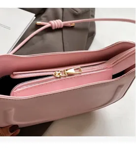 Close-up of pink PU leather bag showing the smooth golden metal zipper and interior
