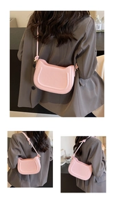 Detail of light pink saddle shoulder bag with U-shaped embossed pattern and knotted strap