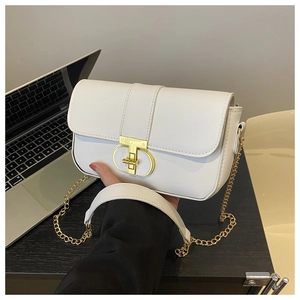 Chic white leather chain bag with gold D-buckle closure for women on a modern desk