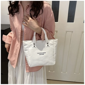 Sac seau en toile blanche avec imprimé mode noir et détails de rivets métalliques