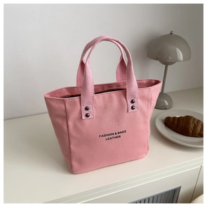 Sac seau en toile rose avec typographie noire et détails de rivets métalliques