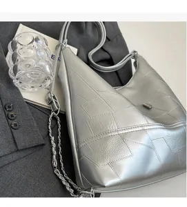 Detail view of silver geometric hobo bag with metallic texture and chain strap