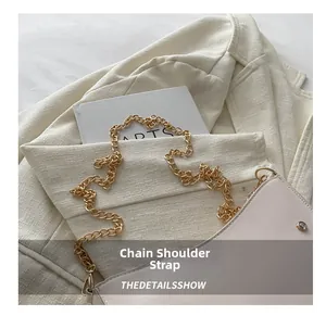 Detail view of pink shoulder bag featuring a gold chain strap and metal rivet accents