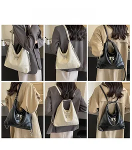 Fashionable large hobo bag with metal butterfly detail and chain strap on models