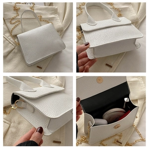 Détails du sac à main blanc grainé montrant l'espace intérieur et la chaîne dorée