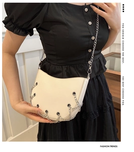 Detail of cream crescent bag with silver chain weaving and metallic eyelet decor