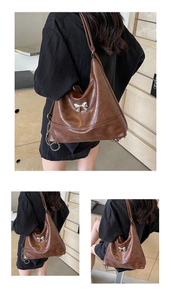 Detail of vintage brown leather hobo bag with silver bow buckle and soft texture