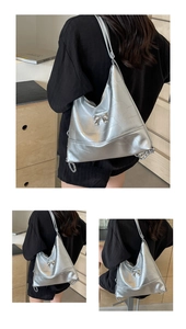 Silver metallic hobo bag detail with bow ornament, chain strap and stitched texture
