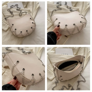 Close-up of cream half-moon bag with silver rivets, chain details and internal pockets