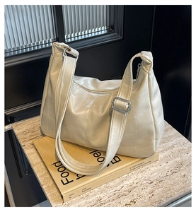 Detail of off-white Hobo bag with adjustable shoulder strap and silver metal buckle