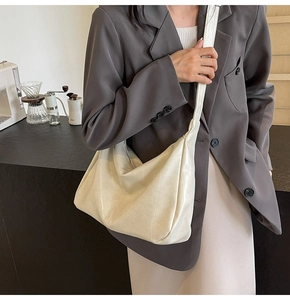 Close-up of beige tote bag with soft pleated leather texture and wide shoulder strap
