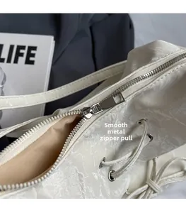 Detail of high-quality silver metal zipper on white marbled texture shoulder bag